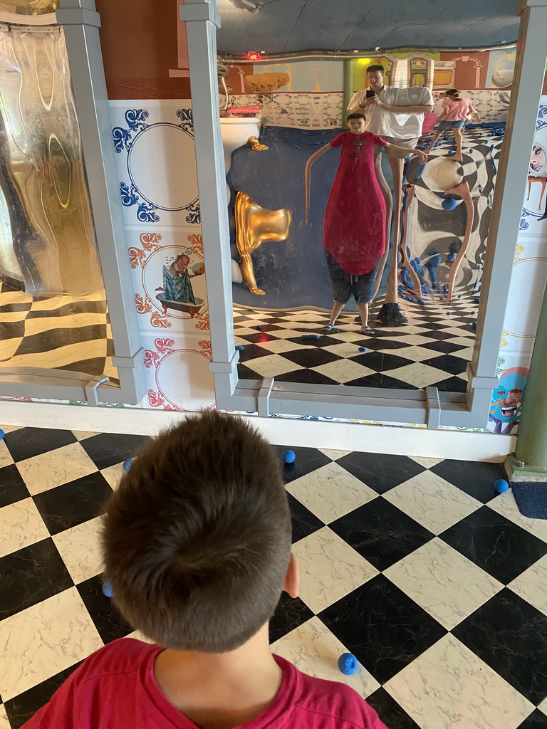 Tim and Max in a distorting mirror at the Huis in de Heuvel building at the Speelwijck area of the Plaswijckpark recreation park