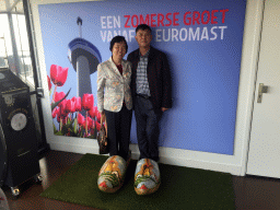 Miaomiao`s parents in wooden shoes, at the entrance to the viewing platforms of the Euromast tower