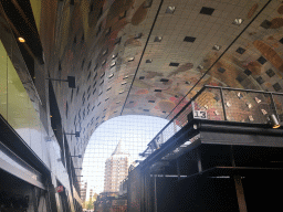 The Markthal building with its ceiling and market stalls, with a view on the Blaaktoren tower