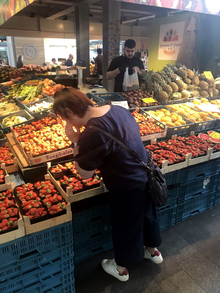 Miaomiao in front of a market stall with fruit in the Markthal building