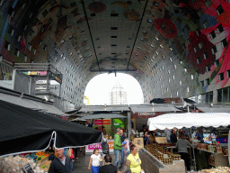 The Markthal building with its ceiling and market stalls, with a view on the Blaaktoren tower