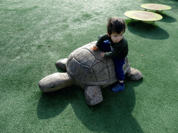 Max on a turtle statue at the playground in front of the theatre of the Vrije Vlucht Voorstelling at the South America area at the Diergaarde Blijdorp zoo