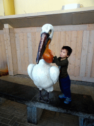 Max with a Pelican statue at the Biotopia playground in the Rivièrahal building at the Africa area at the Diergaarde Blijdorp zoo