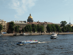 Boats in the Neva river, the west side tower of the Admiralty and the dome of Saint Isaac`s Cathedral, viewed from the Palace Bridge over the Neva river