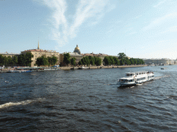 Boats in the Neva river, the towers of the Admiralty and the dome of Saint Isaac`s Cathedral, viewed from the Palace Bridge over the Neva river