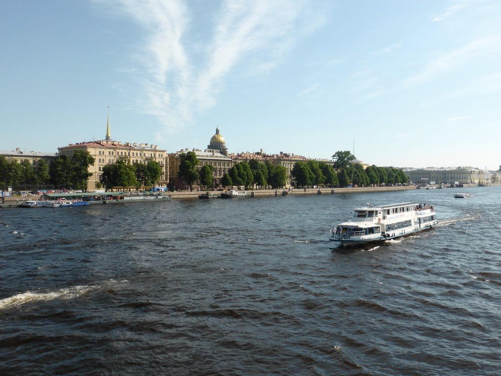 Boats in the Neva river, the towers of the Admiralty and the dome of Saint Isaac`s Cathedral, viewed from the Palace Bridge over the Neva river