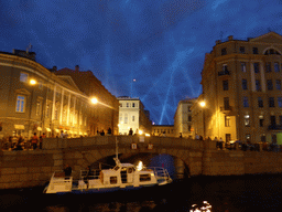 Boat in the Moika river and the First Winter Bridge over the Winter Canal, by night