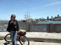 Miaomiao with bike, and boats in San Francisco Bay and the skyline of San Francisco, with the Transatlantic Pyramid