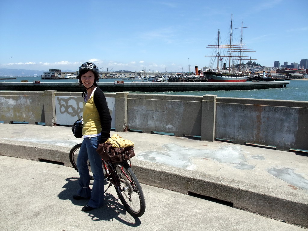 Mengjin with bike, and boats in San Francisco Bay and the skyline of San Francisco