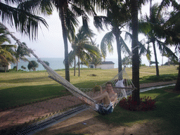 Tim drinking from a coconut in a hammock at the Gloria Resort Sanya