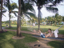 Tim drinking from a coconut in a hammock at the Gloria Resort Sanya
