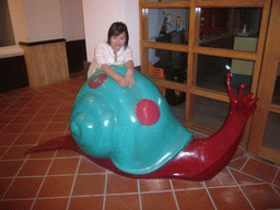 Miaomiao with a snail statue in the lobby of the Gloria Resort Sanya