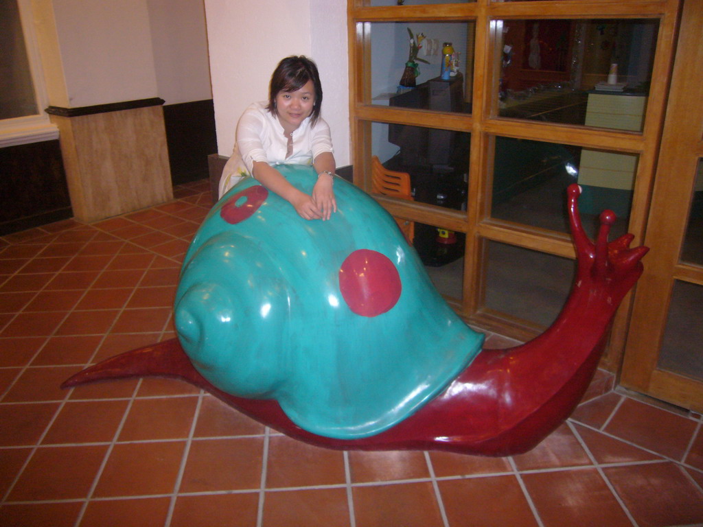 Miaomiao with a snail statue in the lobby of the Gloria Resort Sanya
