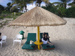Miaomiao in a lounge chair under an umbrella at the private beach of Gloria Resort Sanya