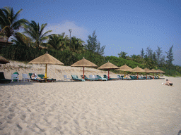 Tim in a lounge chair under an umbrella at the private beach of Gloria Resort Sanya