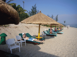 Tim in a lounge chair under an umbrella at the private beach of Gloria Resort Sanya