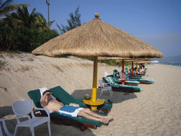 Tim in a lounge chair under an umbrella at the private beach of Gloria Resort Sanya