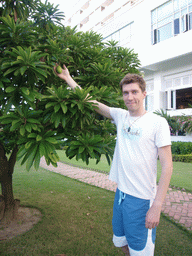 Tim with fruit hanging from a tree at the gardens of the Gloria Resort Sanya