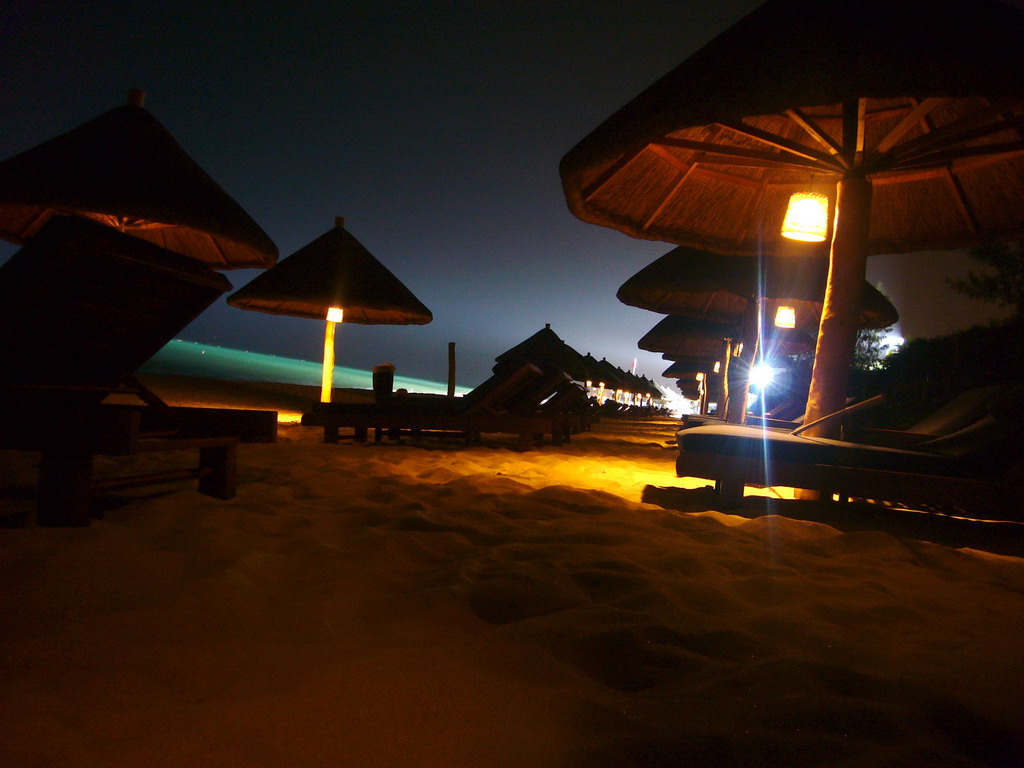 Umbrella with lamps at the beach of Yalong Bay, by night
