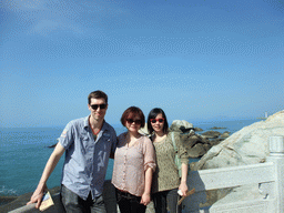 Tim, Miaomiao and Mengjin with rocks at the beach of the Sanya Nanshan Dongtian Park