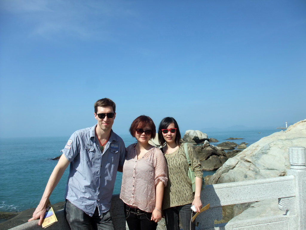 Tim, Miaomiao and Mengjin with rocks at the beach of the Sanya Nanshan Dongtian Park