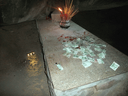 Altar with burning incense and money in the Minor Grotto Heaven at the Sanya Nanshan Dongtian Park