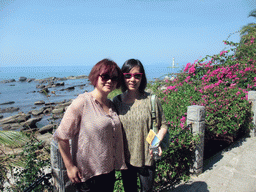 Miaomiao and Mengjin with plants and the Tower at Territorial Sea Base Point at the Sanya Nanshan Dongtian Park