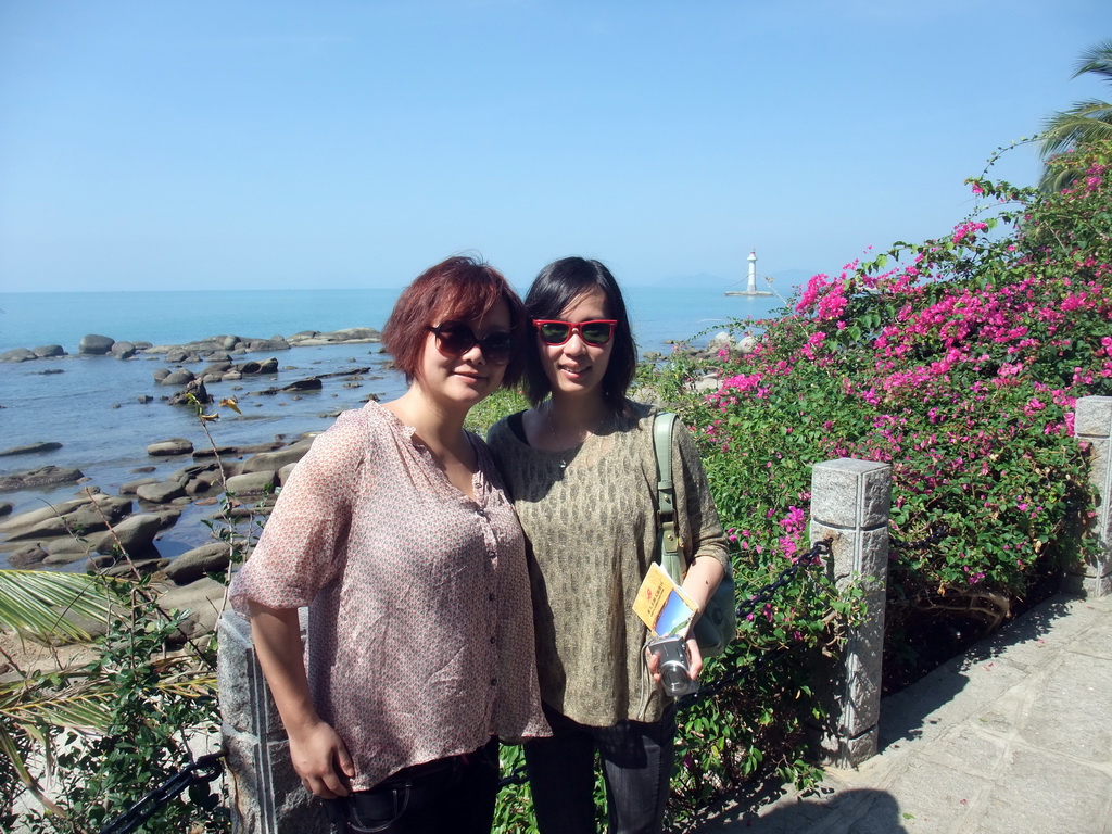 Miaomiao and Mengjin with plants and the Tower at Territorial Sea Base Point at the Sanya Nanshan Dongtian Park