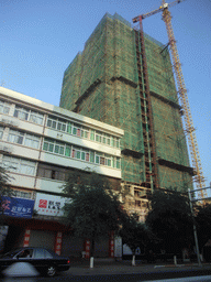 Building under construction at a street in the city center, viewed from a car