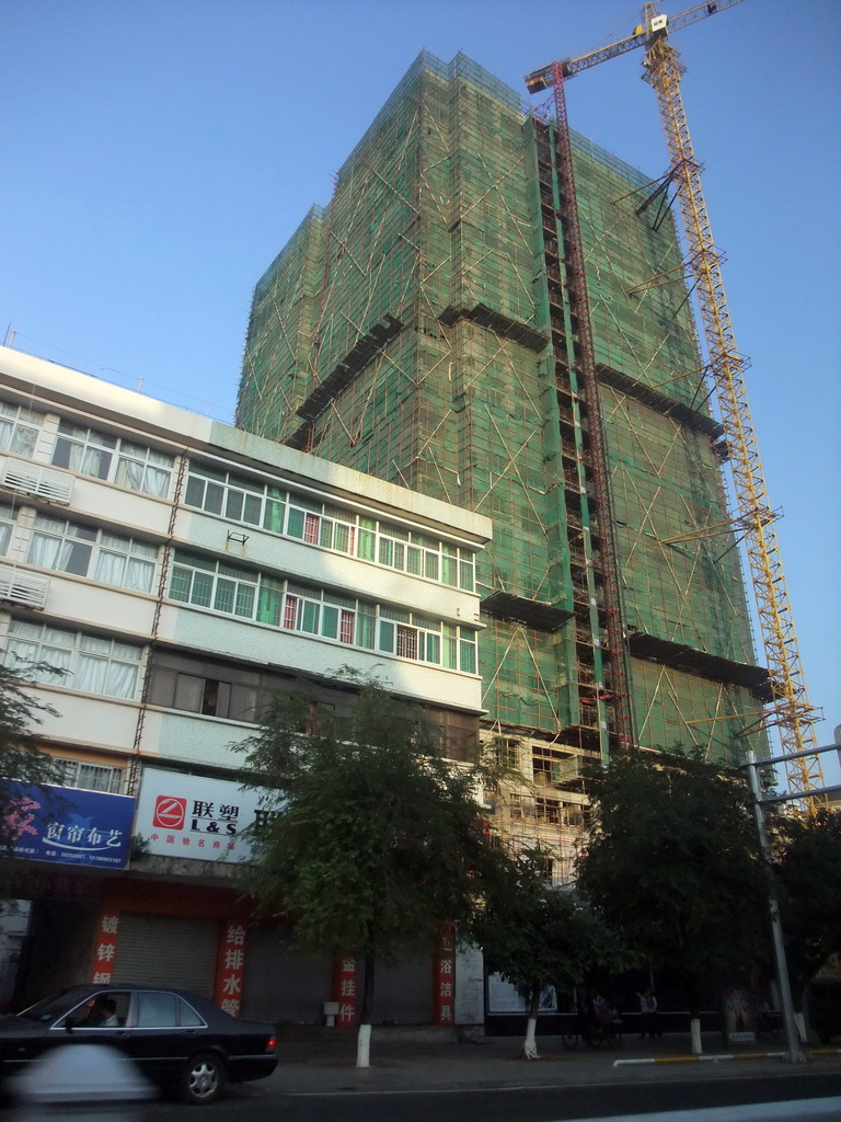 Building under construction at a street in the city center, viewed from a car