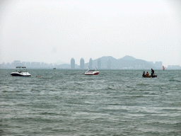 Boats in the sea in front of the Ocean Sonic Resort, with a view on the skyline of Sanya