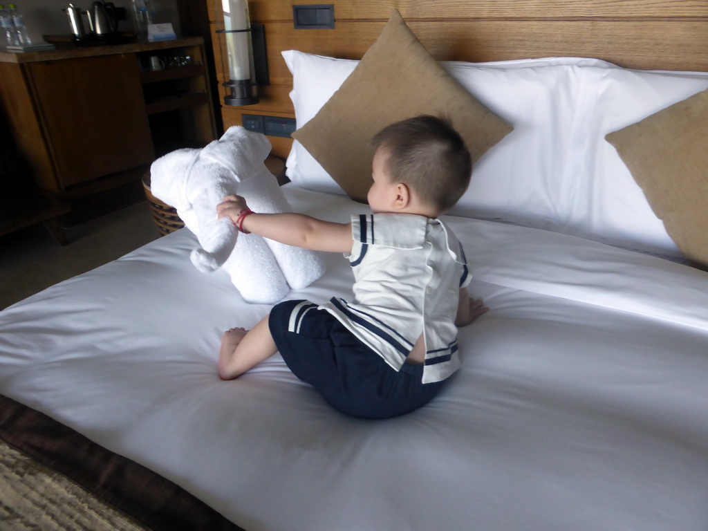 Max with a towel on the bed in our room at the InterContinental Sanya Haitang Bay Resort