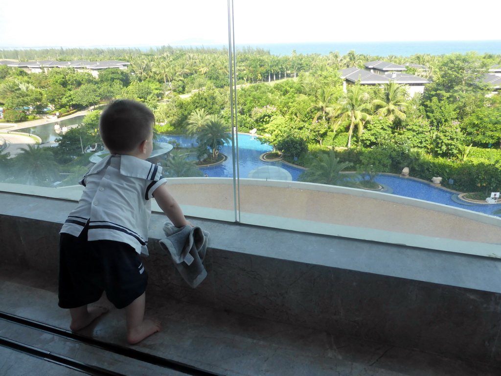 Max on the balcony of our room at the InterContinental Sanya Haitang Bay Resort, with a view on the swimming pool and Haitang Bay