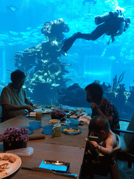 Miaomiao`s parents and Max having lunch in front of the aquarium with a diver and fish at the Aqua restaurant at the InterContinental Sanya Haitang Bay Resort