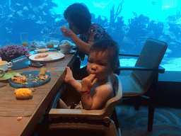 Max and Miaomiao`s mother having lunch in front of the aquarium with fish at the Aqua restaurant at the InterContinental Sanya Haitang Bay Resort