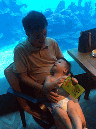 Max and Miaomiao`s father in front of the aquarium with fish at the Aqua restaurant at the InterContinental Sanya Haitang Bay Resort