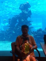 Max and Miaomiao`s father in front of the aquarium with fish at the Aqua restaurant at the InterContinental Sanya Haitang Bay Resort