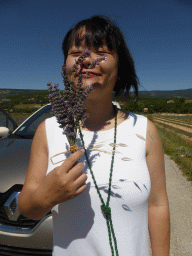 Miaomiao with a branch of lavender and our rental car at a lavender field at the west side of the town