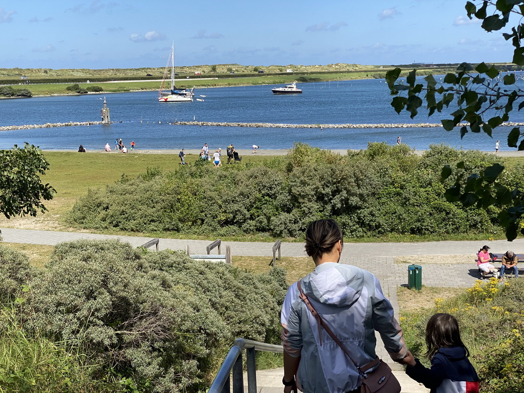 Miaomiao and Max on the staircase from the Rampweg road to the West Repart beach, with a view on the Brouwersdam and boats in the Grevelingenmeer lake