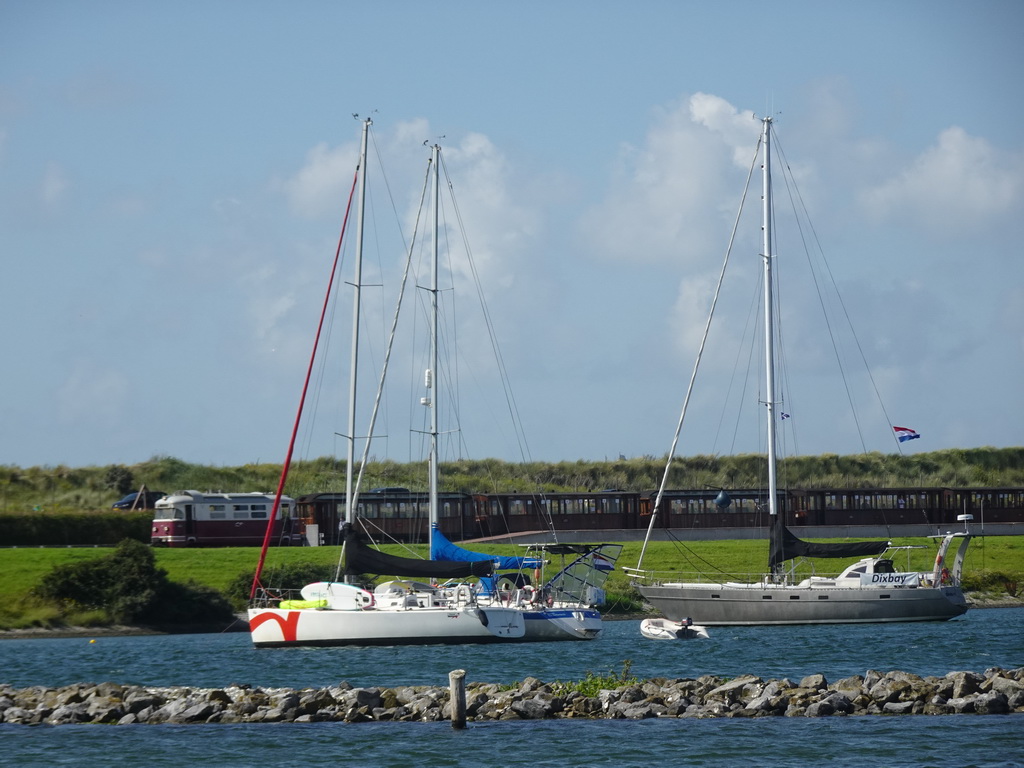 Old train at the Brouwersdam and boats in the Grevelingenmeer lake, viewed from the West Repart beach