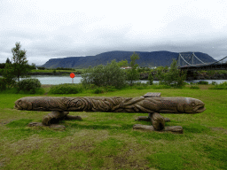 Wooden pole at the parking place of Hotel Selfoss, with a view on the Ölfusárbrú bridge over the Ölfusá river