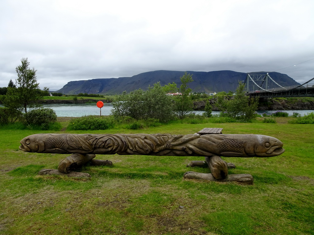 Wooden pole at the parking place of Hotel Selfoss, with a view on the Ölfusárbrú bridge over the Ölfusá river