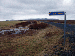 Sign, grassland and mountains at a town near the Seljalandsfoss waterfall