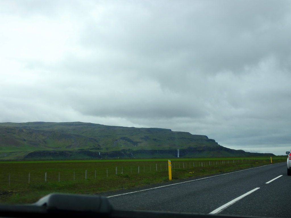 The Gljúfrabúi and Seljalandsfoss waterfalls, viewed from the rental car on the Þjóðvegur road