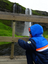 Max on the bridge over the stream in front of the Seljalandsfoss waterfall