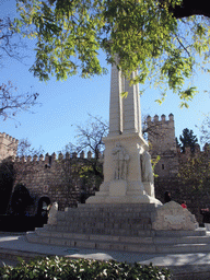 Monument of the Immaculate Conception at the Plaza del Triunfo square, and the northern wall of the Alcázar of Seville with entrance to the Patio de Banderas courtyard