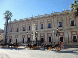 The Triunfo monument, the Archivo General de Indias and horses and carriages at the Plaza del Triunfo square