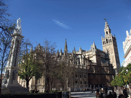 The Monument of the Immaculate Conception and the east side of the Seville Cathedral with the Giralda tower at the Plaza del Triunfo square