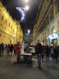 Tim with chestnut salesman in the Avenida de la Constitución avenue at the west side of the Seville Cathedral, by night