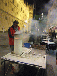 Chestnut salesman in the Avenida de la Constitución avenue at the west side of the Seville Cathedral, by night